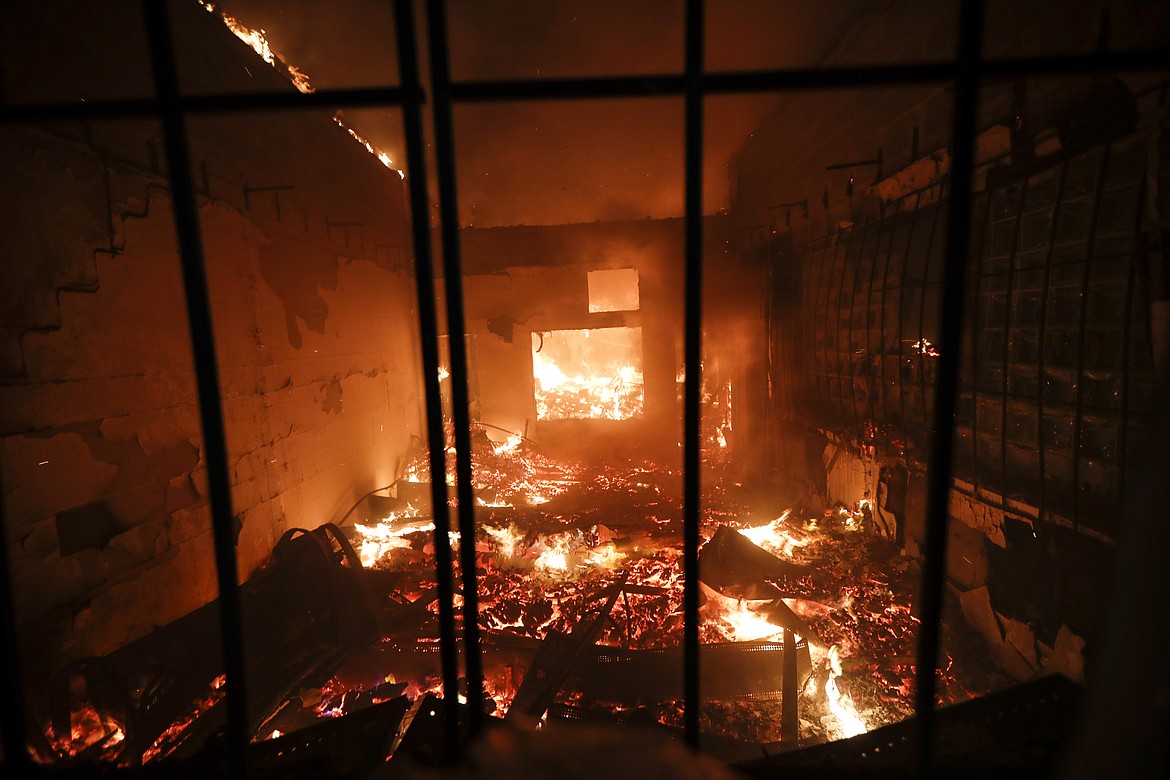 A liquor store is burnt during protests near the Minneapolis 3rd Police Precinct, Thursday, May 28, 2020, in Minneapolis. Protests over the death of George Floyd, a black man who died in police custody Monday, broke out in Minneapolis for a third straight night. (AP Photo/John Minchillo)