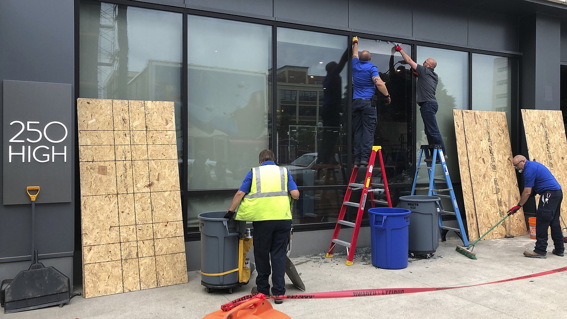 Workers repair smashed windows at a building south of downtown on Friday, May 29, 2020, in Columbus, Ohio. Multiple downtown storefronts had their windows smashed and some businesses were looted early Friday. The damage happened as protesters angry over the death of George Floyd in Minneapolis police custody turned out for a demonstration in Columbus that began peacefully but turned violent, with windows smashed at the Ohio Statehouse and storefronts along surrounding downtown streets. (AP Photo/Andrew Welsh-Huggins)