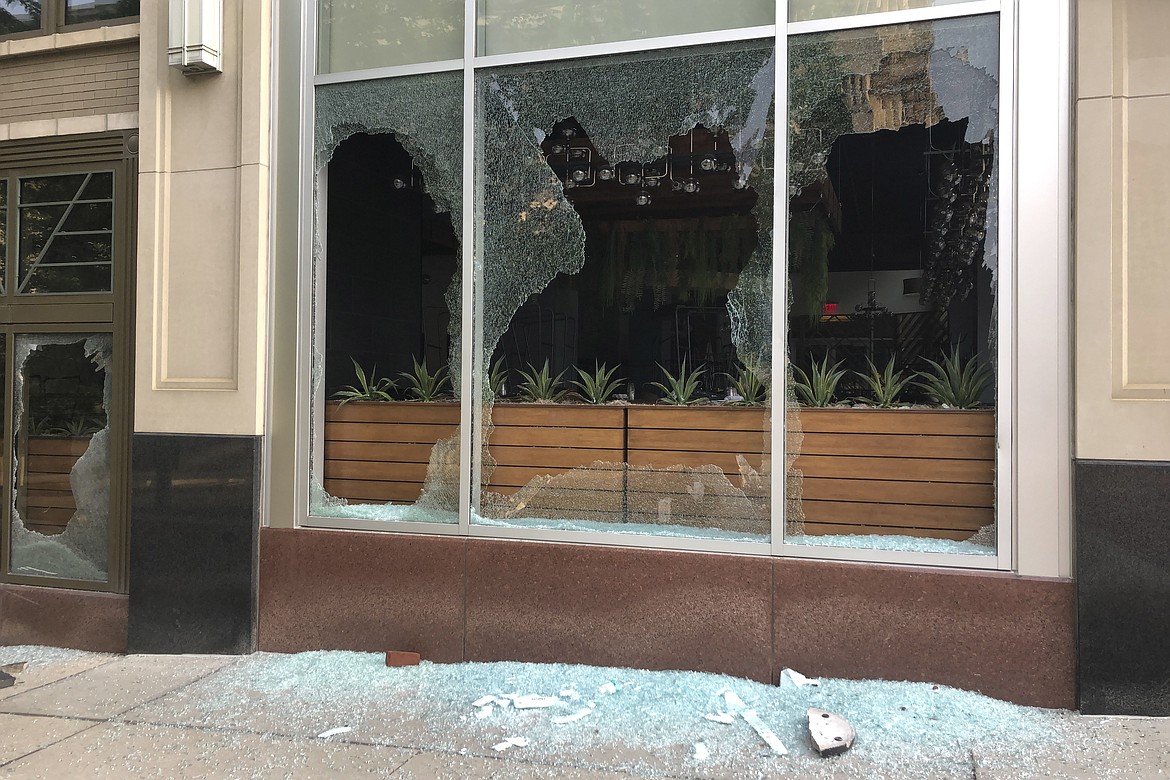 Smashed windows at a building show the damage after a night of protests on Friday, May 29, 2020, in Columbus, Ohio.  The damage happened as protesters angry over the death of George Floyd in Minneapolis police custody turned out for a demonstration in Columbus that began peacefully but turned violent, with windows smashed at the Ohio Statehouse and storefronts along surrounding downtown streets. (AP Photo/Andrew Welsh-Huggins)
