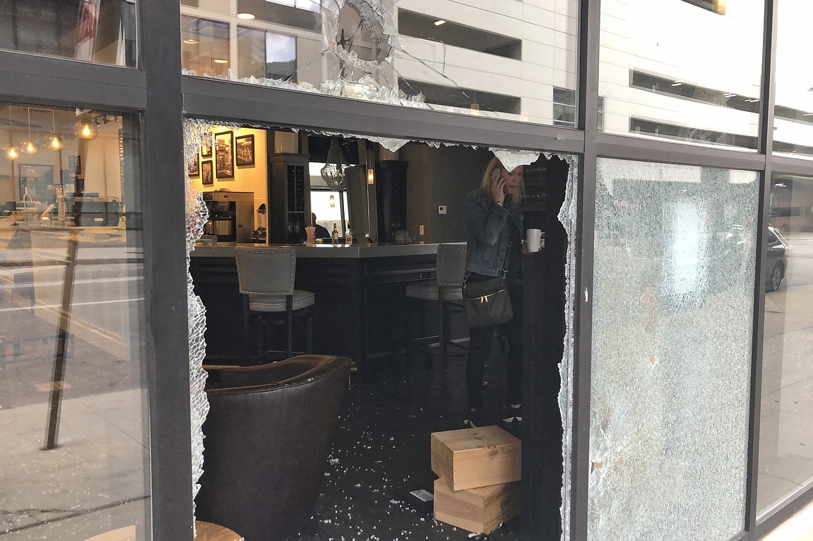 Monica Thomas, franchise owner of Winan's Chocolates + Coffees + Wine, talks on the phone inside her smashed up shop on Friday, May 29, 2020, in Columbus, Ohio.  The damage happened early Friday as protesters angry over the death of George Floyd in Minneapolis police custody turned out for a demonstration in Columbus that began peacefully but turned violent, with windows smashed at the Ohio Statehouse and storefronts along surrounding downtown streets. (AP Photo/Andrew Welsh-Huggins)