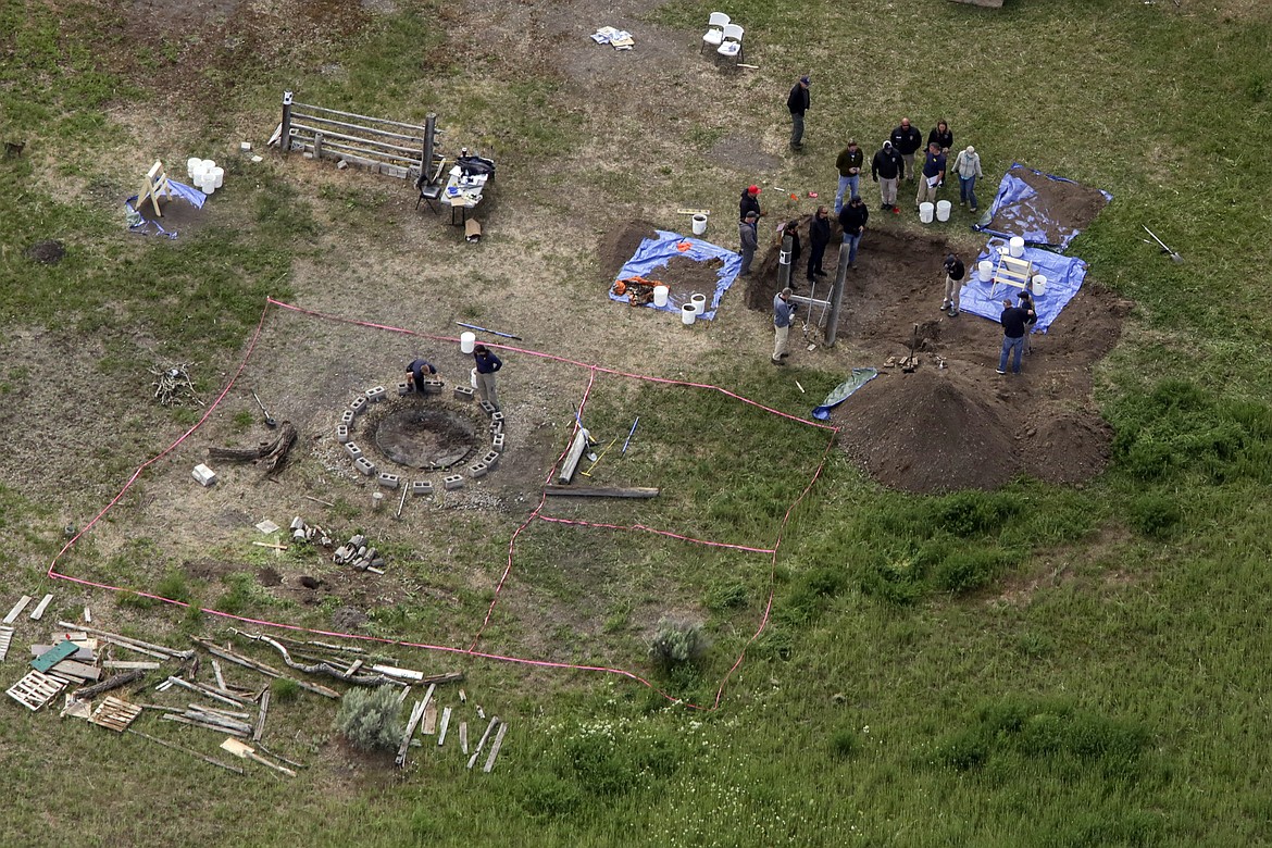 In this aerial photo, investigators search for human remains at Chad Daybell's residence in the 200 block of 1900 east, Tuesday, June 9, 2020, in Salem, Idaho. Authorities say they uncovered human remains at Daybell's home as they investigated the disappearance of his new wife’s two children. Police in the small town of Rexburg say Daybell was taken into custody Tuesday. He had recently married the children’s mother, Lori Vallow Daybell, who has been charged with child abandonment. (John Roark/The Idaho Post-Register via AP)