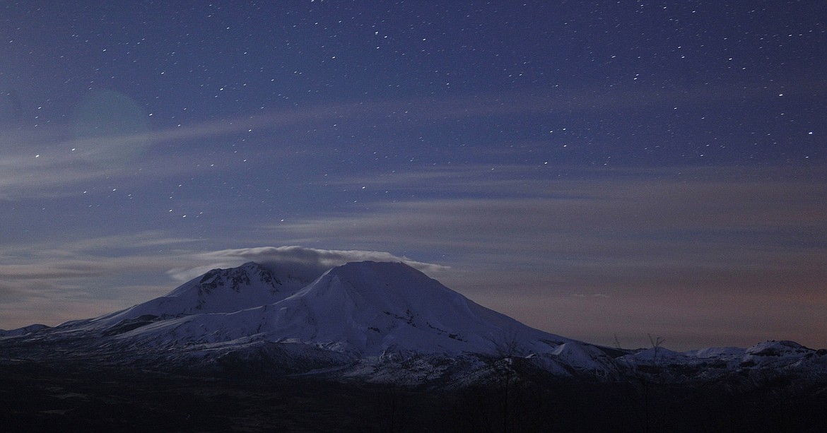 FILE - In this May 7, 2010, file photo, Mount St. Helens stands against a backdrop of stars just before sunrise in Washington state. May 18, 2020, is the 40th anniversary of the eruption that killed more than 50 people and blasted more than 1,300 feet off the mountain's peak. (AP Photo/Ted S. Warren, File)