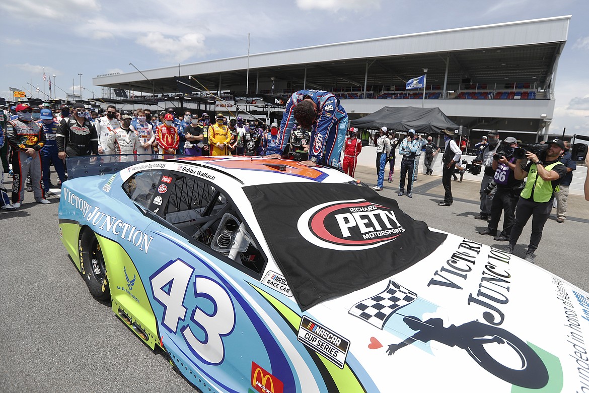 Driver Bubba Wallace, front, is overcome with emotion as he arrives at his car in the pits of the Talladega Superspeedway prior to the start of the NASCAR Cup Series auto race at the Talladega Superspeedway in Talladega Ala., Monday June 22, 2020. In an extraordinary act of solidarity with NASCAR’s only Black driver, dozens of drivers pushed the car belonging to Bubba Wallace to the front of the field before Monday’s race as FBI agents nearby tried to find out who left a noose in his garage stall over the weekend. (AP Photo/John Bazemore)