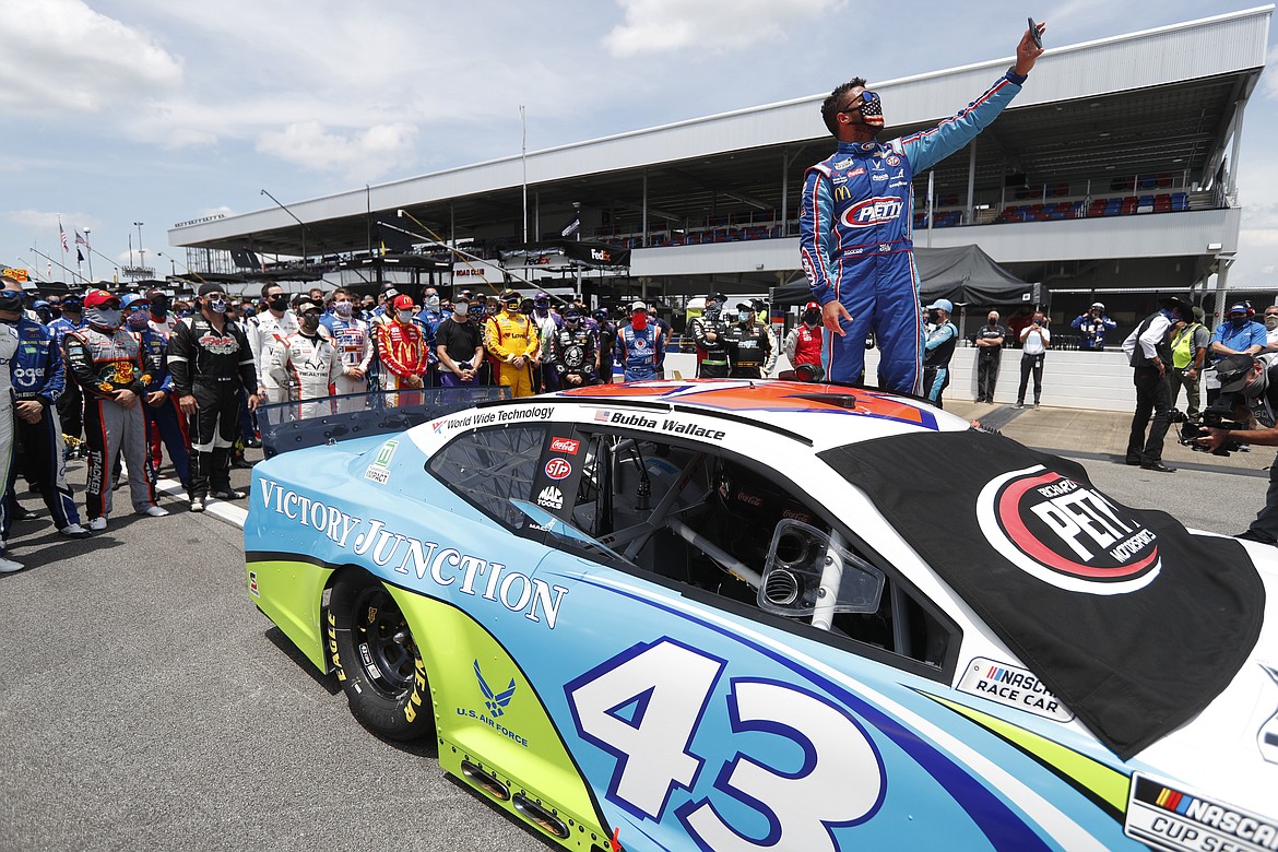 Driver Bubba Wallace takes a selfie with himself and other drivers that pushed his car to the front in the pits of the Talladega Superspeedway prior to the start of the NASCAR Cup Series auto race at the Talladega Superspeedway in Talladega Ala., Monday June 22, 2020. In an extraordinary act of solidarity with NASCAR’s only Black driver, dozens of drivers pushed the car belonging to Bubba Wallace to the front of the field before Monday’s race as FBI agents nearby tried to find out who left a noose in his garage stall over the weekend.  (AP Photo/John Bazemore)