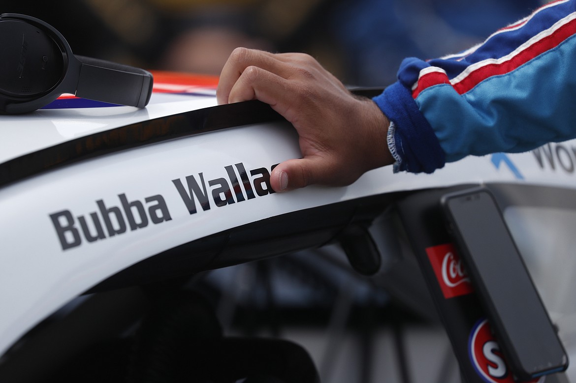 Driver Bubba Wallace leans on his car in the pits of the Talladega Superspeedway prior to the start of the NASCAR Cup Series auto race at the Talladega Superspeedway in Talladega Ala., Monday June 22, 2020.  (AP Photo/John Bazemore)