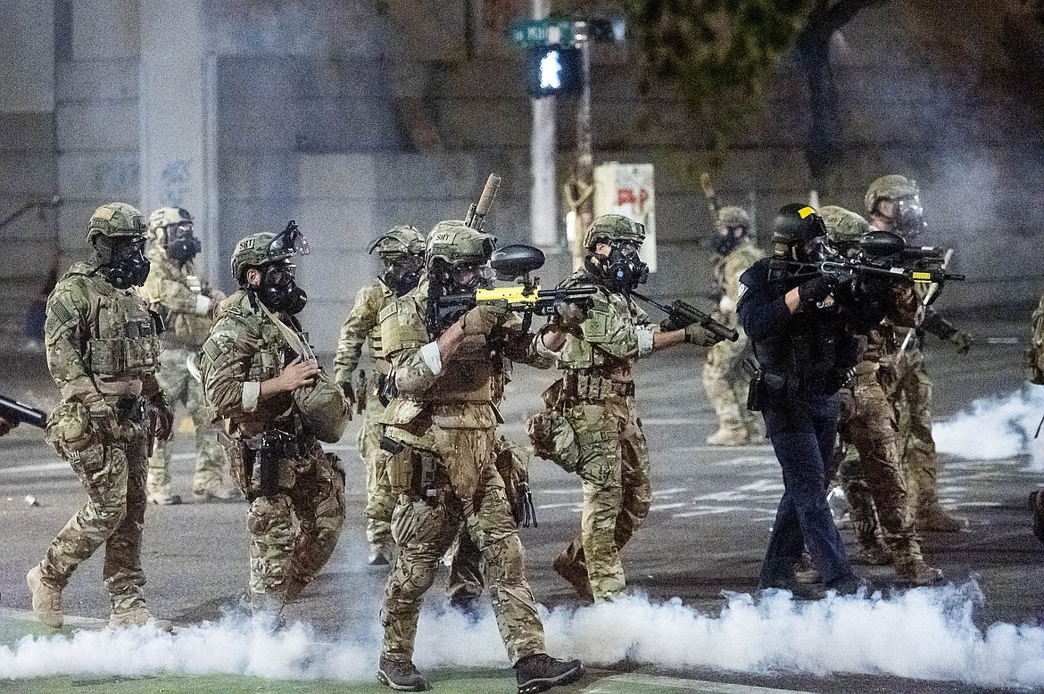 Federal agents use crowd control munitions to disperse Black Lives Matter protesters at the Mark O. Hatfield United States Courthouse in Portland, Ore. on July 20, 2020. Officers used teargas and projectiles to move the crowd after some protesters tore down a fence fronting the courthouse. (AP Photo/Noah Berger)