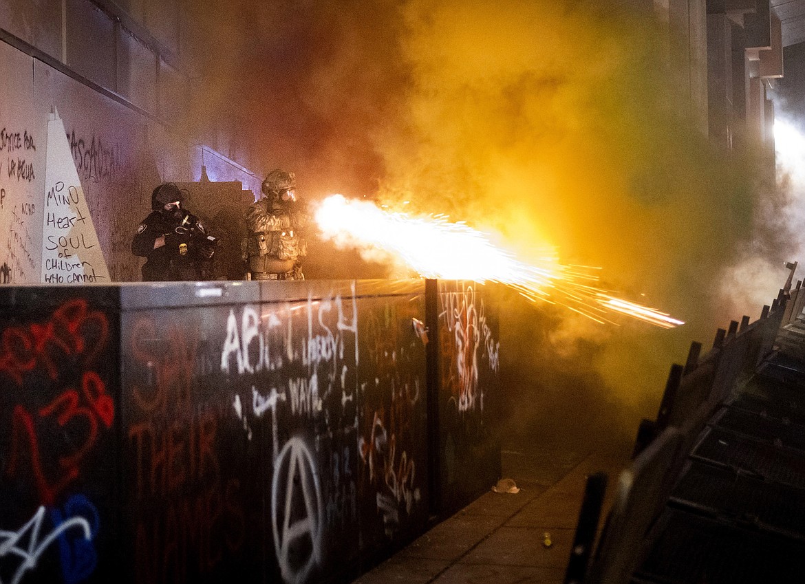 Federal agents use crowd control munitions to disperse Black Lives Matter protesters at the Mark O. Hatfield United States Courthouse in Portland, Ore. on July 19, 2020. Officers used teargas and projectiles to move the crowd after some protesters tore down a fence fronting the courthouse. (AP Photo/Noah Berger)