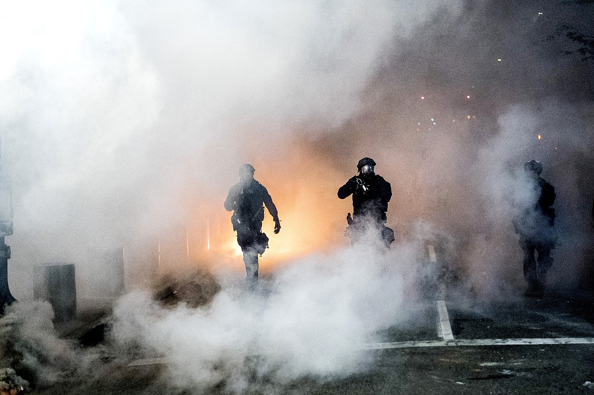 Federal officers use crowd control munitions to disperse Black Lives Matter protesters outside the Mark O. Hatfield United States Courthouse in Portland, Ore. July 21, 2020. (AP Photo/Noah Berger)