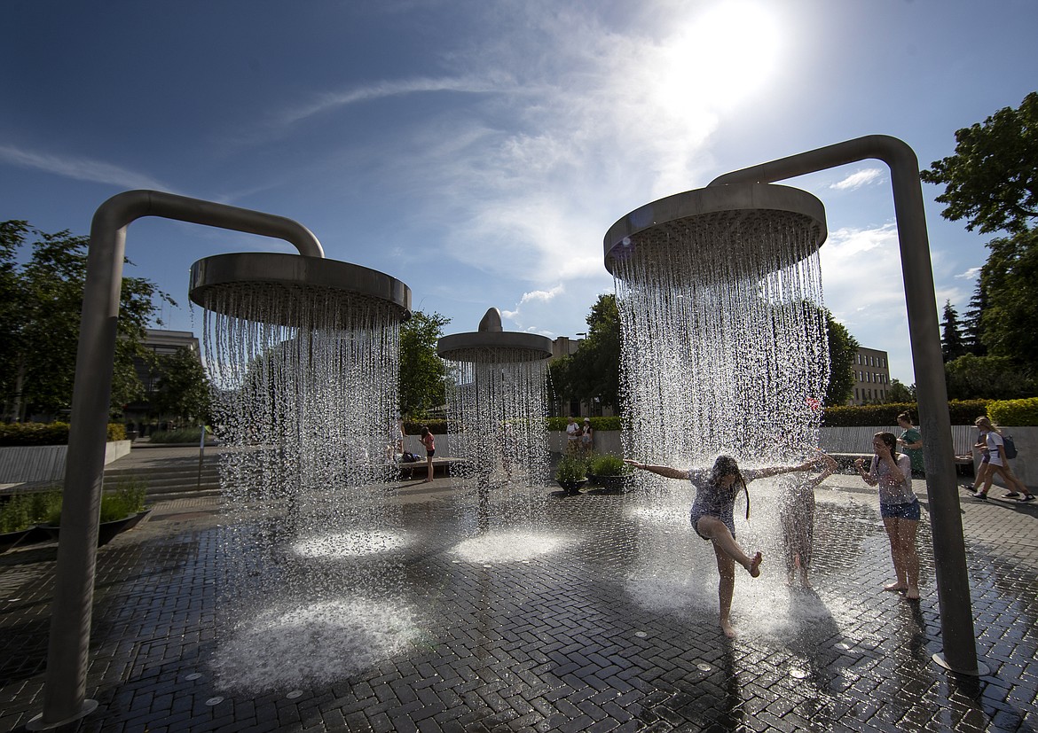 Children cool off in a public fountain in Vilnius, Lithuania, Friday, June 19, 2020. Heat wave continues in the Lithuania as temperature goes up high at 32 degrees Celsius (89.6 degrees Fahrenheit). (AP Photo/Mindaugas Kulbis)