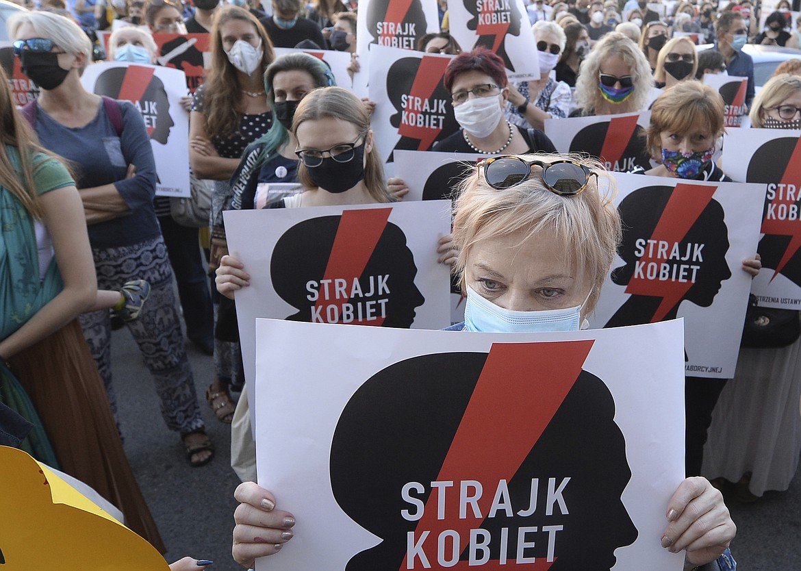 Women with the signs of "Women's Strike" rights organization protest against plans by the right-wing government to withdraw from Europe's Istanbul Convention on prevention of violence against women and children, in Warsaw, Poland, Friday,  July 24, 2020 (AP Photo/Czarek Sokolowski)