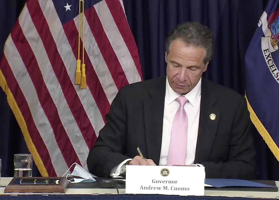 In this photo made from video provided by the office of New York Governor Andrew M. Cuomo, Gov. Cuomo, signs into law, Friday, June 12, 2020, in New York, a sweeping package of police accountability measures that received new backing following protests of George Floyd's killing. The laws signed by Cuomo, a Democrat, will ban police chokeholds, make it easier to sue people who call police on others without good reason, and set up a special prosecutor's office to investigate the deaths of people during and following encounters with police officers. (Office of New York Governor Andrew M. Cuomo via AP)