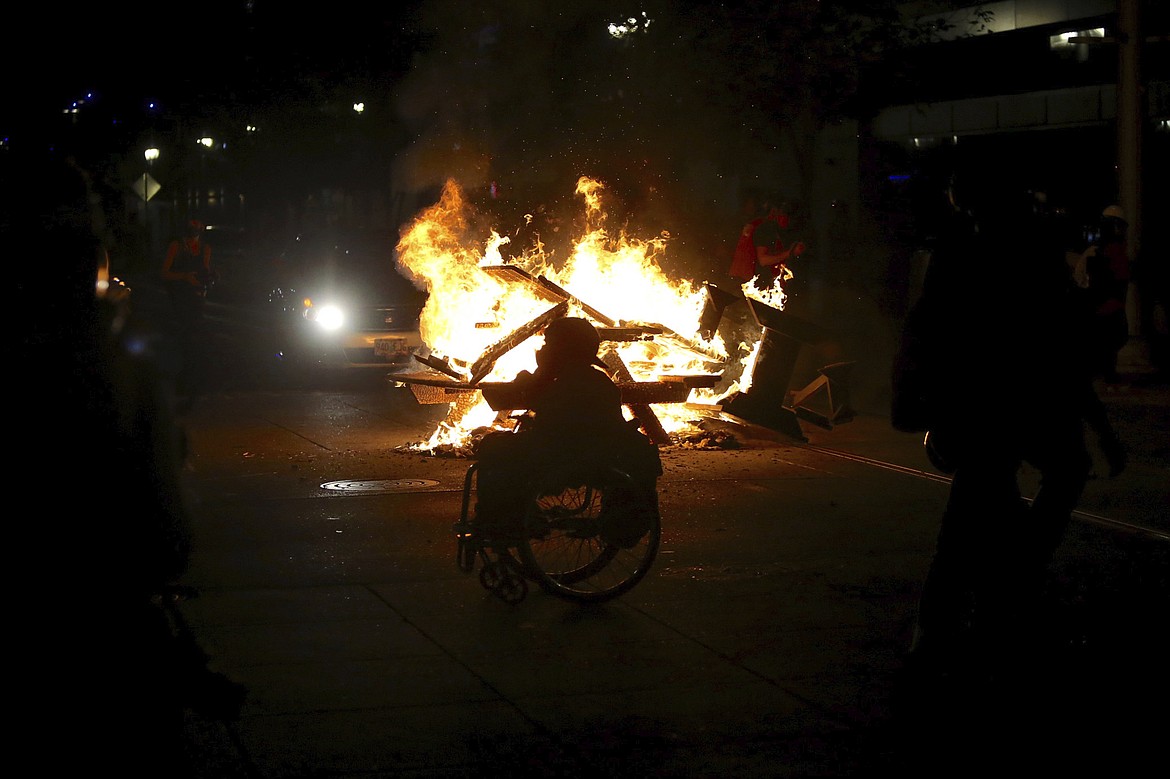Protesters start a fire during in Portland, Ore., on Wednesday, Aug. 19, 2020.  Protesters in Portland have clashed with federal agents for the first time since July in a demonstration that targeted a U.S. Immigration and Customs Enforcement building.(Sean Meagher/The Oregonian via AP)