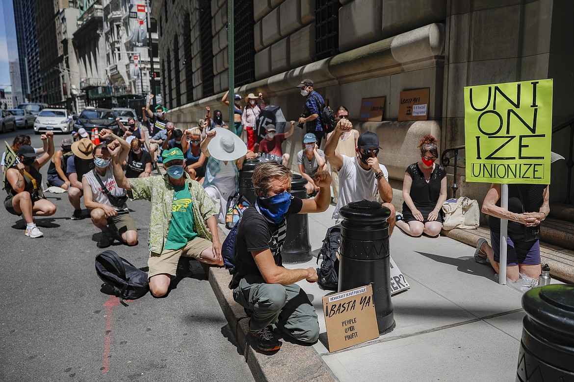 Protesters gather for a rally outside the Federal Reserve in the Financial District, Monday, July 20, 2020, in the Manhattan borough of New York. Thousands across the country planned to walked off the job to protest systemic racism and economic inequality that has worsened during the coronavirus pandemic. (AP Photo/John Minchillo)