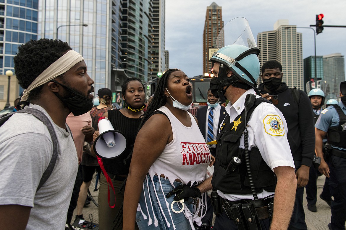 A Chicago police officer is blocked by activists as he attempts to arrest someone at the intersection of Roosevelt Rd. and Columbus Dr., Monday, July 20, 2020 in Chicago. (Tyler LaRiviere/Chicago Sun-Times via AP)