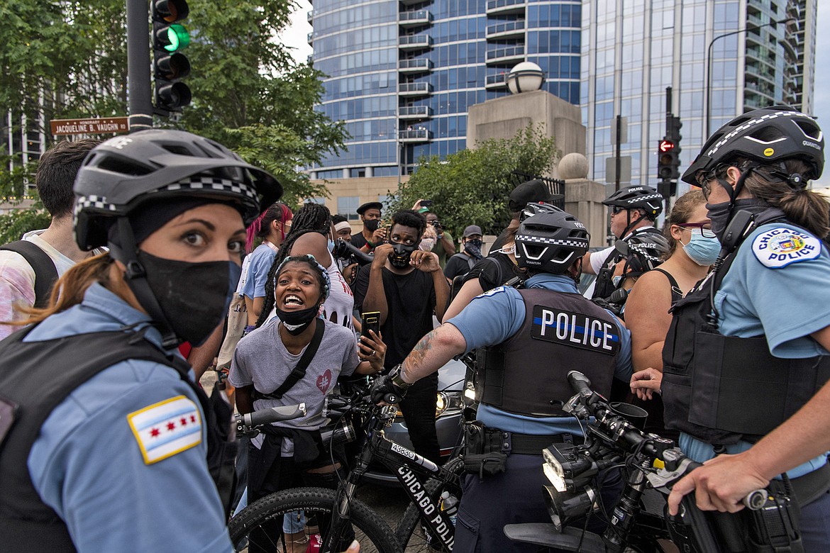 Chicago police and activists crowd around a vehicle that tried to drive through the protesters circle at the intersection of Roosevelt Rd. and Columbus Dr, Monday, July 20, 2020 in Chicago. (Tyler LaRiviere/Chicago Sun-Times via AP)