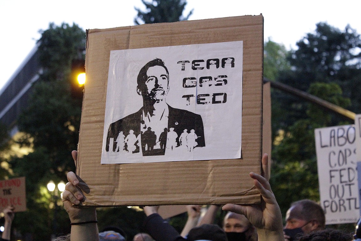 Demonstrators protest in downtown Portland, Ore., Wednesday, July 22, 2020. Gov. Ted Wheeler faced a hostile crowd of protesters, who screamed at and sharply questioned him as he tried to rally demonstrators who have clashed repeatedly with federal agents sent in by President Donald Trump to quell ongoing unrest in the city. (AP Photo/Gillian Flaccus)