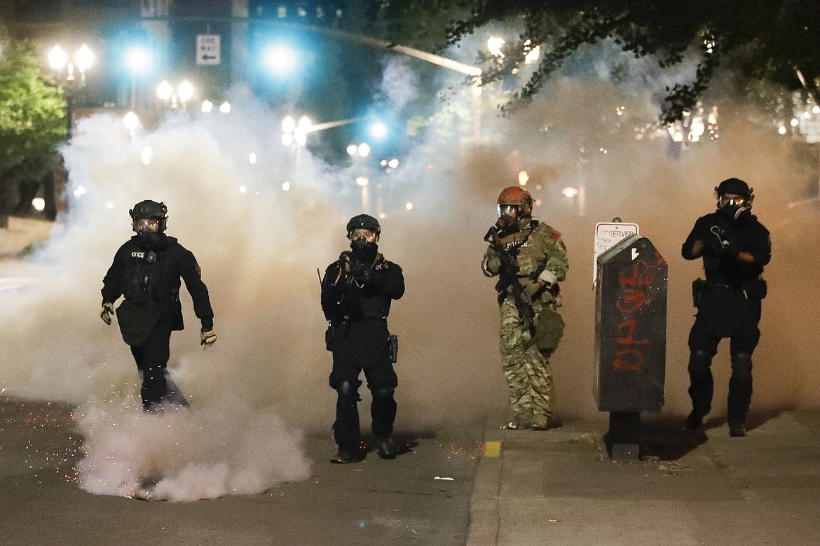 Federal officers advance of demonstrators during a Black Lives Matter protest at the Mark O. Hatfield United States Courthouse Monday, July 27, 2020, in Portland, Ore. (AP Photo/Marcio Jose Sanchez)