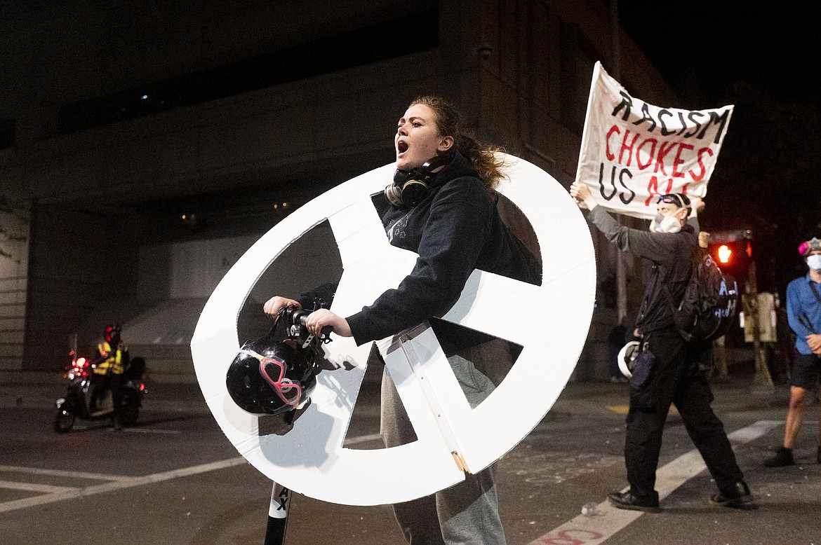 KaCe Freeman chants during a Black Lives Matter protest outside the Mark O. Hatfield United States Courthouse on Monday, July 20, 2020, in Portland, Ore. Portland police early Monday detailed another night of conflict between protesters and federal forces outside the U.S. courthouse in Oregon's largest city, including a small fire outside the building and tear gas deployed to disperse the crowd. (AP Photo/Noah Berger)