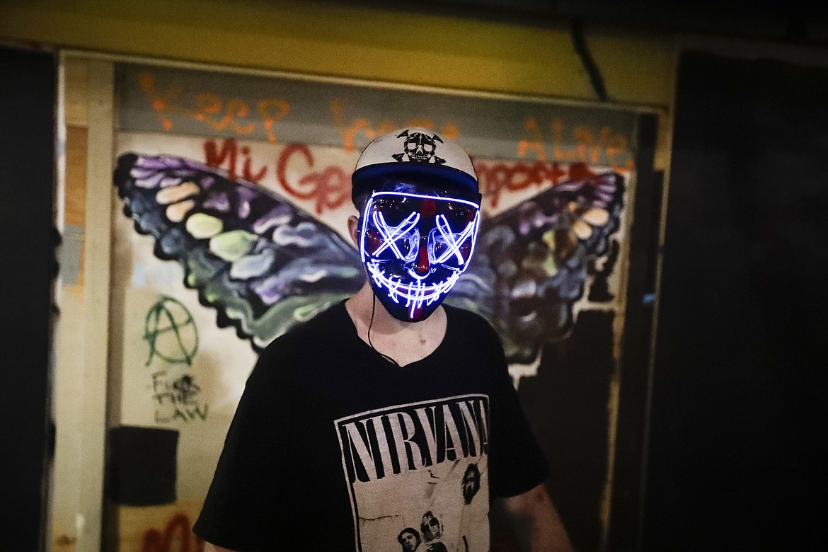 A protester wears a colorful mask during a Black Lives Matter protest at the Mark O. Hatfield United States Courthouse Thursday, July 30, 2020, in Portland, Ore. After days of clashes with federal police, the crowd outside of the federal courthouse remained peaceful Thursday night. (AP Photo/Marcio Jose Sanchez)