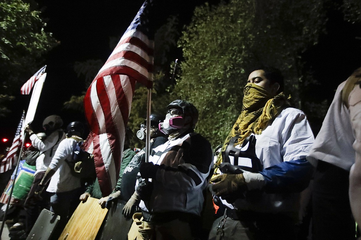 Military veterans participate in a Black Lives Matter protest at the Mark O. Hatfield United States Courthouse Thursday, July 30, 2020, in Portland, Ore. After days of clashes with federal police, the crowd outside of the federal courthouse remained peaceful Thursday night. (AP Photo/Marcio Jose Sanchez)