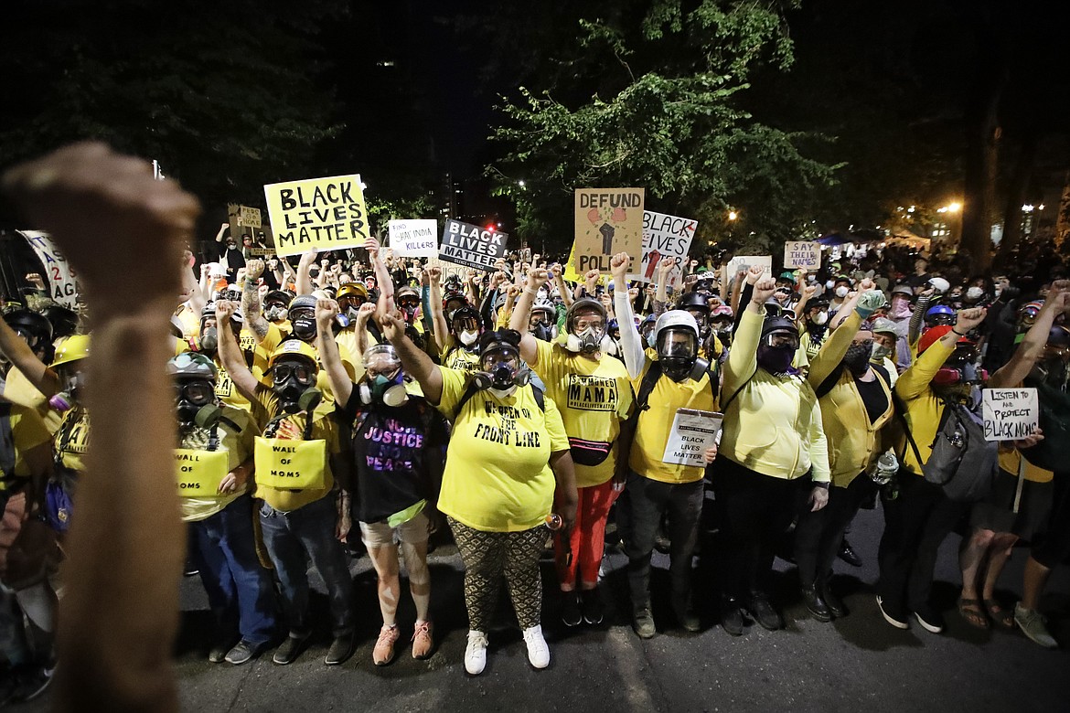 A member of the "Wall of Moms" protest group marches with other demonstrators during a Black Lives Matter protest at the Mark O. Hatfield United States Courthouse Tuesday, July 28, 2020, in Portland, Ore. (AP Photo/Marcio Jose Sanchez)