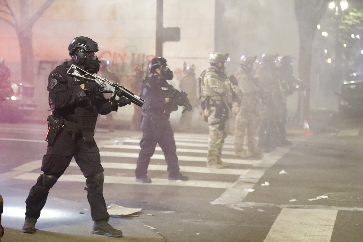 Federal officers deploy tear gas and crowd control munitions at demonstrators during a Black Lives Matter protest at the Mark O. Hatfield United States Courthouse Tuesday, July 28, 2020, in Portland, Ore. (AP Photo/Marcio Jose Sanchez)