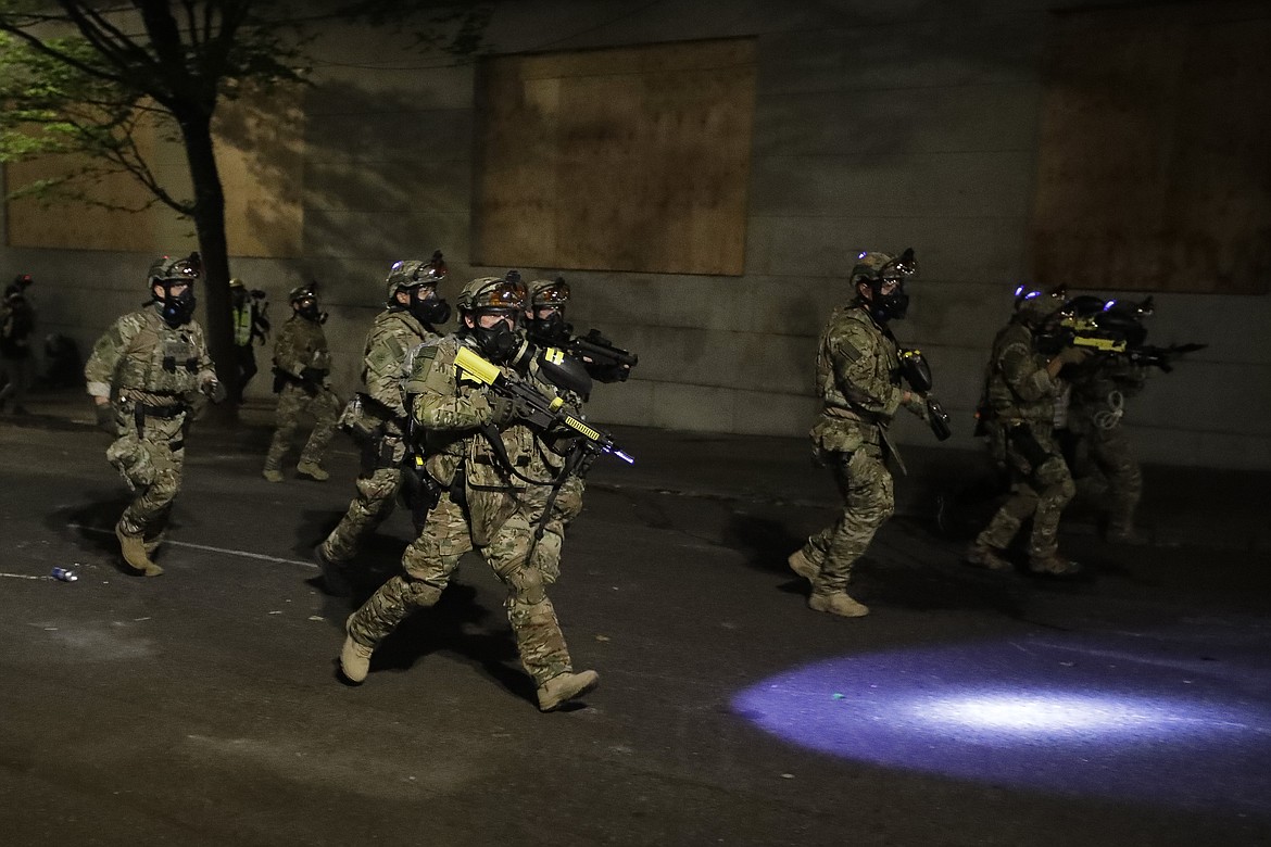 Federal officers advance on retreating demonstrators after an illegal assembly was declared during a Black Lives Matter protest at the Mark O. Hatfield United States Courthouse Wednesday, July 29, 2020, in Portland, Ore. (AP Photo/Marcio Jose Sanchez)