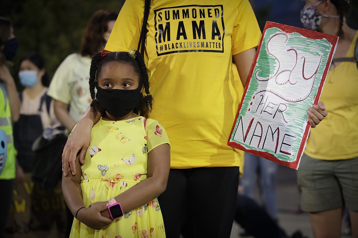 Zoe, 6, and her mother Lacey, no last names given, prepare to march during a Black Lives Matter protest Tuesday, July 28, 2020, in Portland, Ore. (AP Photo/Marcio Jose Sanchez)