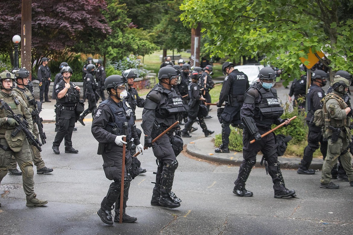 Seattle Police finish their sweep Wednesday, July 1, 2020, on the north end of Cal Anderson Park, sweeping everyone off the grounds.  (Steve Ringman/The Seattle Times via AP)