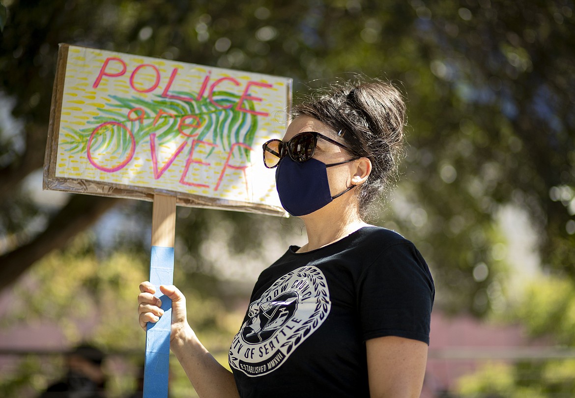 Protestors block Fourth Avenue outside Seattle City Hall and listen to Monday's Seattle City Council budget committee voting, which included potential Seattle Police Department cuts, Monday, Aug. 10, 2020. Organizers said the protest puts pressure on defunding Seattle Police and reallocating funds into the Black community.  (Erika Schultz/The Seattle Times via AP)