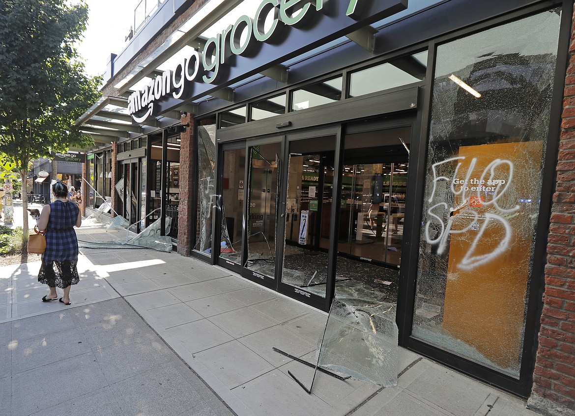 Broken windows and graffiti are shown at the Amazon Go grocery store, Sunday, July 19, 2020 in Seattle. Protesters broke windows at the store earlier in the afternoon. (AP Photo/Ted S. Warren)