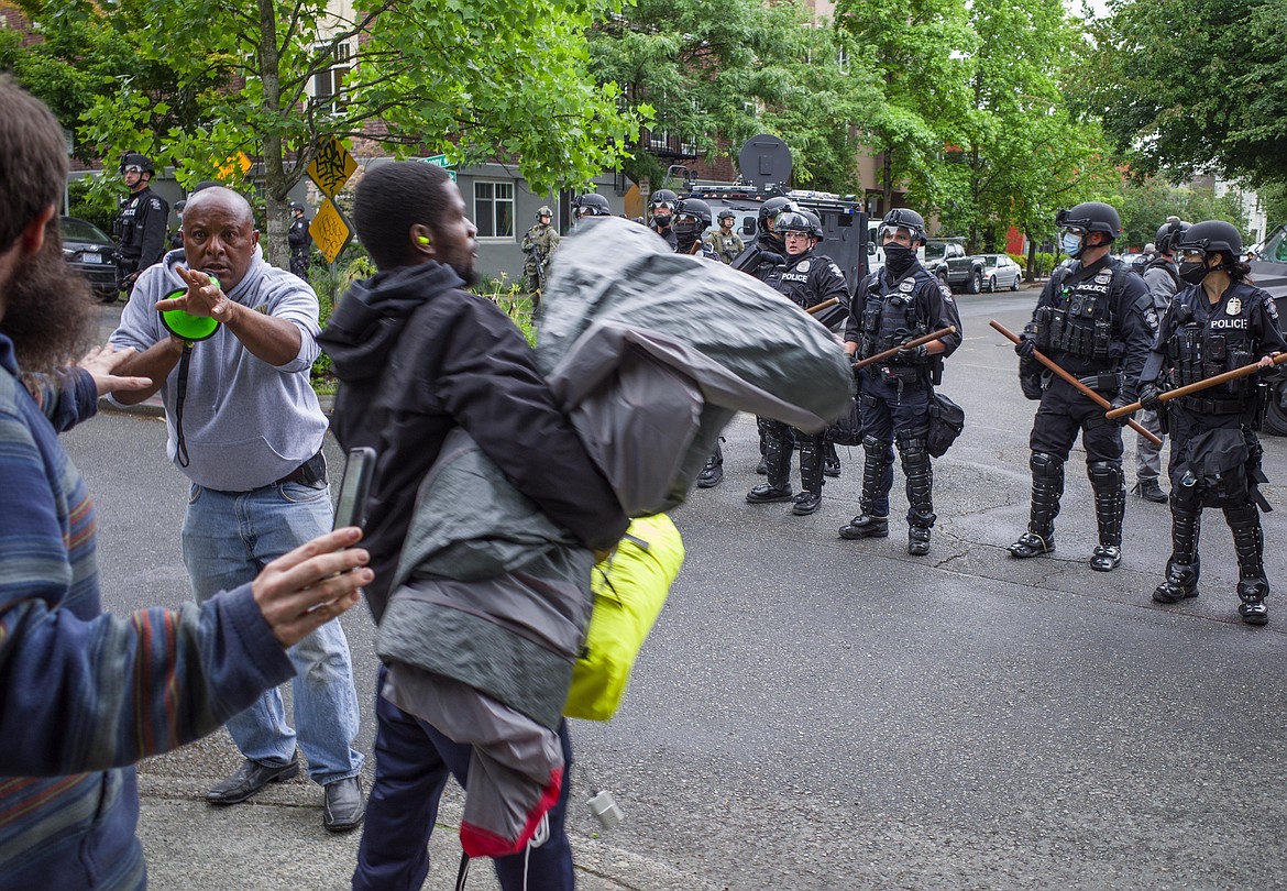 Emotions were running high Wednesday, July 1, 2020, in Seattle as a few police officers were telling people to get back and out of the Cal Anderson Park to help stop the violence as the sweep continued. (Steve Ringman/The Seattle Times via AP)