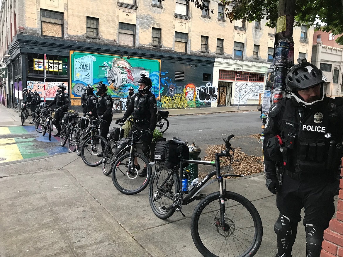 Seattle police block a street with their bicycles in the Capitol Hill Organized Protest zone early Wednesday, July 1, 2020. Police in Seattle have torn down demonstrators' tents in the city's occupied protest zone after the mayor ordered it cleared. (AP Photo/Aron Ranen)