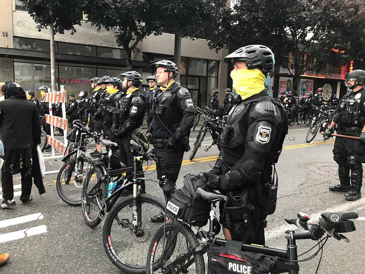 Seattle police block a street with their bikes in the Capitol Hill Organized Protest zone early Wednesday, July 1, 2020. Police in Seattle have torn down demonstrators' tents in the city's occupied protest zone after the mayor ordered it cleared. (AP Photo/Aron Ranen)