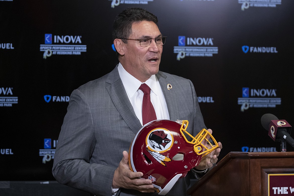 FILE - In this Jan. 2, 2020, file photo, Washington Redskins head coach Ron Rivera holds up a helmet during a news conference at the team's NFL football training facility in Ashburn, Va. A new name must still be selected for the Washington Redskins football team, one of the oldest and most storied teams in the National Football League, and it was unclear how soon that will happen. But for now, arguably the most polarizing name in North American professional sports is gone at a time of reckoning over racial injustice, iconography and racism in the U.S. (AP Photo/Alex Brandon, File)