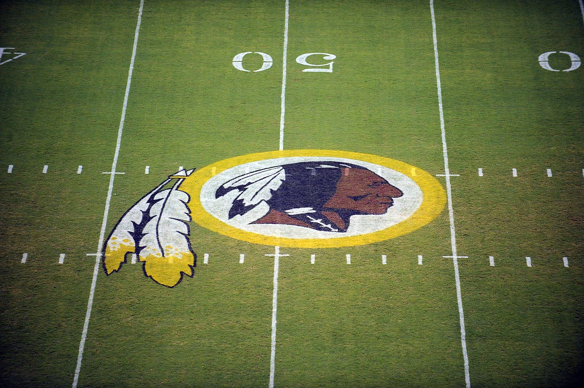 FILE - In this Aug. 28, 2009 file photo, the Washington Redskins logo is shown on the field before the start of a preseason NFL football game against the New England Patriots in Landover, Md.  The Washington NFL franchise announced Monday that it will drop the “Redskins” name and Indian head logo immediately, bowing to decades of criticism that they are offensive to Native Americans.  (AP Photo/Nick Wass, File)