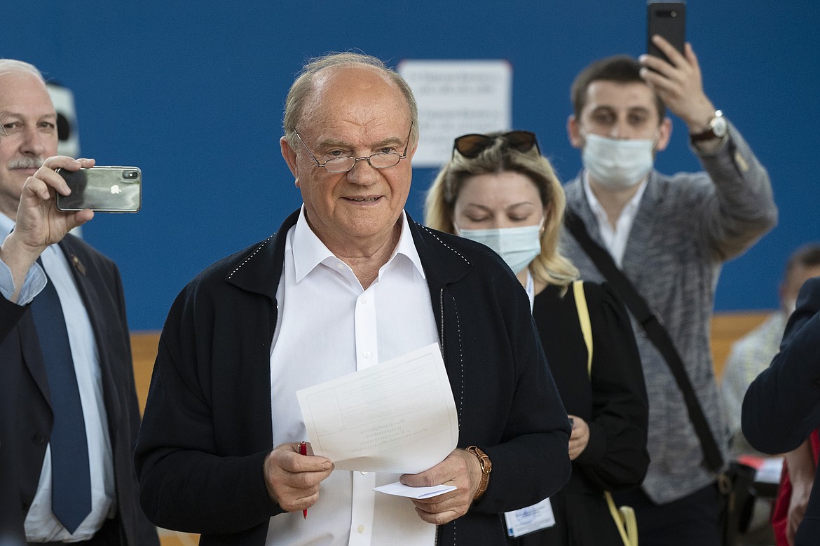 Russian Communist Party leader Gennady Zyuganov, center, prepares to cast his ballot at a polling station in Moscow, Russia, Wednesday, July 1, 2020. The vote on the constitutional amendments that would reset the clock on Russian President Vladimir Putin's tenure and enable him to serve two more six-year terms is set to wrap up Wednesday. (AP Photo/Pavel Golovkin)