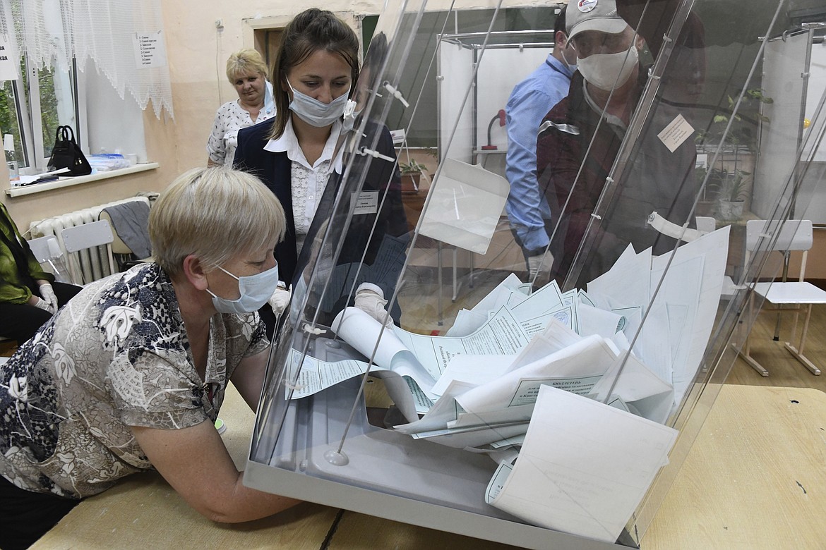 Member of an election commission, wearing face masks and gloves to protect against coronavirus prepare to count ballots after voting at a polling station in eastern Siberian city of Chita, Russia, Wednesday, July 1, 2020. Russia's vote on constitutional amendments that could allow President Vladimir Putin to extend his rule until 2036 entered its final day Wednesday amid widespread reports of pressure on voters and other irregularities. (AP Photo)