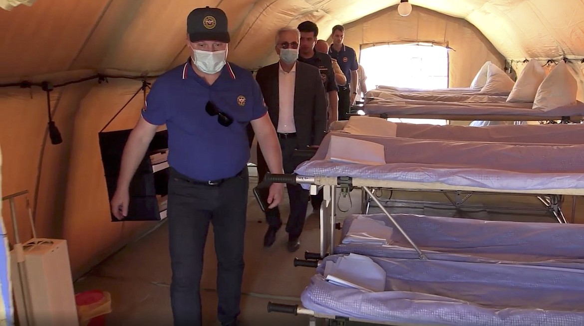 In this photo taken from a footage provided by Russian Emergency Situations Ministry press service, Russian and Lebanese medical specialists visit a Russian field hospital set up in Beirut, Lebanon, on Thursday, Aug. 6, 2020. Russia's emergency officials say the country sent five planeloads of aid to Beirut after an explosion in the Lebanese capital's port killed at least 100 people and injured thousands on Tuesday. Russia's Ministry for Emergency Situations sent rescuers, medical workers, a makeshift hospital and a lab for coronavirus testing to Lebanon. (AP Photo/Ministry of Emergency Situations press service via AP)