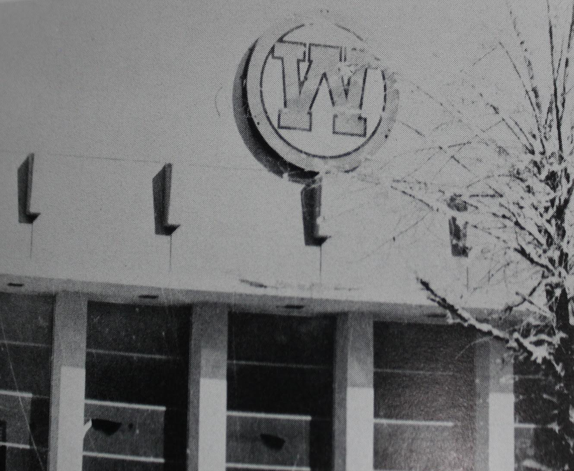 These photos were from old Wallace Jr./Sr. High School yearbooks which show the sign hanging above the entrance to the old gymnasium. Everything on the sign is outlined with neon lights, which the students in Katie Lund’s art class at WHS, along with many other local businesses are working to refurbish.