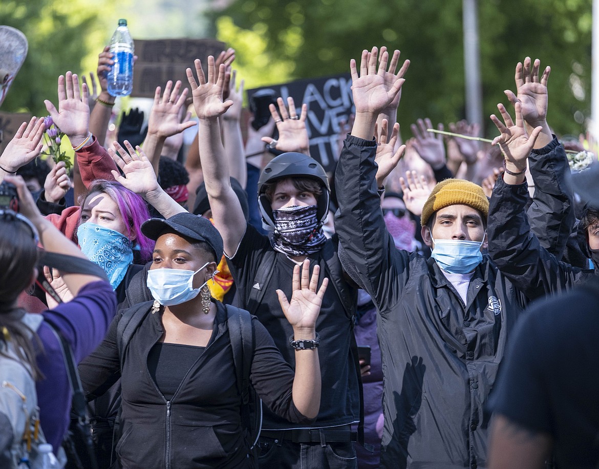 Protesters chant "Hands Up, Don't Shoot" as they march Monday, June 1, 2020, in Seattle. Monday's protests in the city against police violence were peaceful. (Dean Rutz/The Seattle Times via AP)