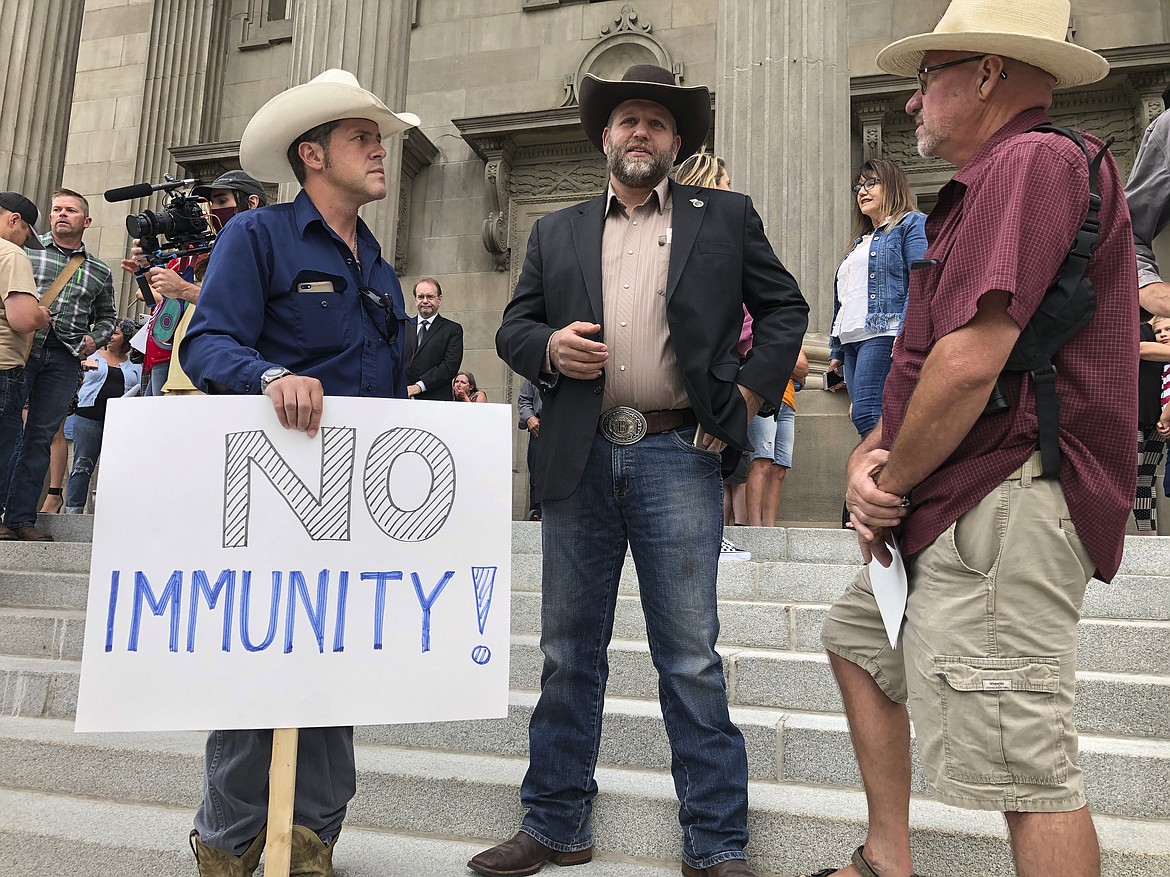 Ammon Bundy, center, who led the Malheur National Wildlife Refuge occupation, stands on the Idaho Statehouse steps in Boise, Idaho, on Monday, Aug. 24, 2020. He's among those attending a special session of the Idaho Legislature called due to the coronavirus pandemic. (AP Photo/Keith Ridler)