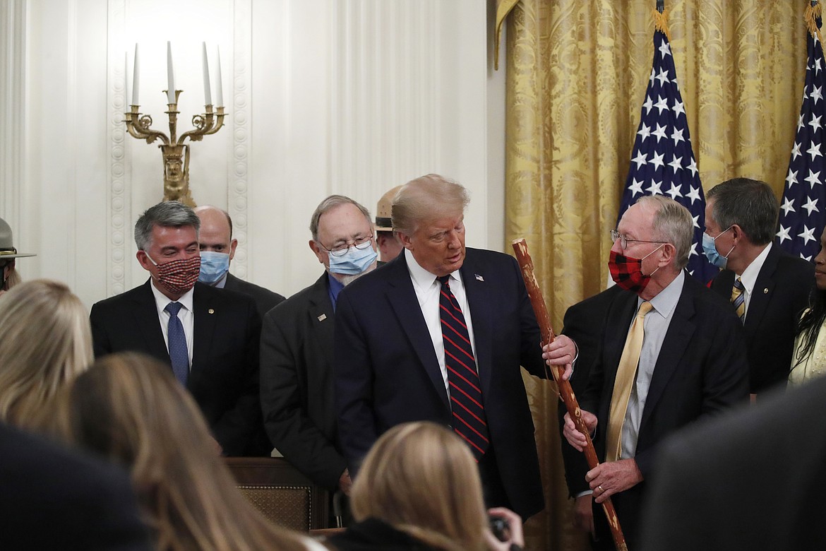 Sen. Lamar Alexander, R-Tenn., gives President Donald Trump a walking stick during a signing ceremony for H.R. 1957 ï¿½ "The Great American Outdoors Act," in the East Room of the White House, Tuesday, Aug. 4, 2020, in Washington. (AP Photo/Alex Brandon)