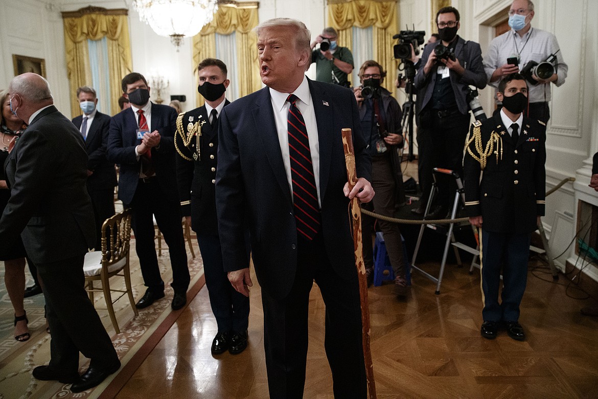 President Donald Trump departs carrying a walking stick given to him by Sen. Lamar Alexander, R-Tenn., after a signing ceremony for H.R. 1957 ï¿½ "The Great American Outdoors Act," in the East Room of the White House, Tuesday, Aug. 4, 2020, in Washington. (AP Photo/Alex Brandon)