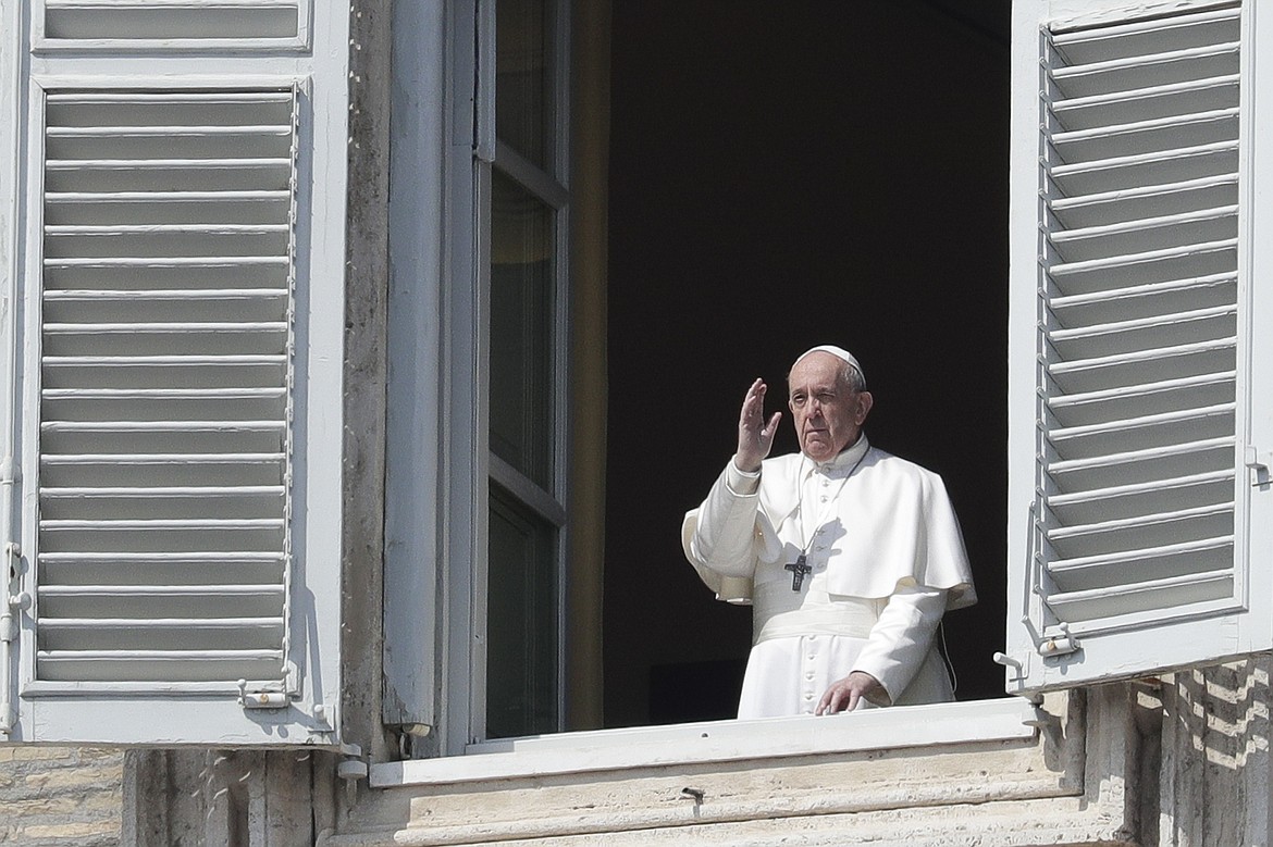 Pope Francis delivers his blessing from the window of his private library overlooking St. Peter's Square, at the Vatican, Sunday, March 22, 2020. During his weekly Sunday blessing, held due to virus concerns in his private library in the Apostolic Palace, he urged all Christians to join in reciting the ‘’Our Father’’ prayer next Wednesday at noon. And he said that he would lead a global blessing to an empty St. Peter’s Square on Friday. For most people, the new coronavirus causes only mild or moderate symptoms. For some it can cause more severe illness, especially in older adults and people with existing health problems. (AP Photo/Andrew Medichini)