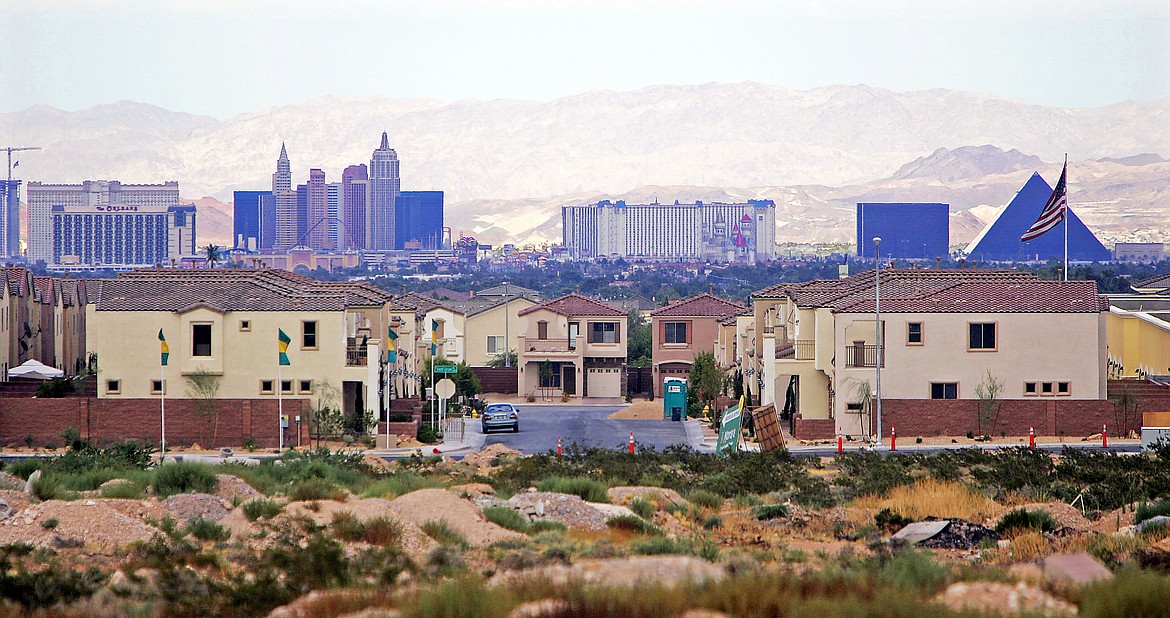 FILE - This Aug. 15, 2005, file photo, shows a housing development with the Las Vegas Strip in the background. Las Vegas-area home prices hit a record high in March, ahead of the economic shutdown prompted by the coronavirus pandemic. Las Vegas Realtors reported Tuesday, April 7, 2020, the median sales price of previously owned single-family homes climbed to $319,000, topping the previous record $316,000 set in February and up 6.3% from March 2019. Home sales were up 5.2% during the month, and up 11.7% for condominiums and townhouses. (AP Photo/Joe Cavaretta, File)