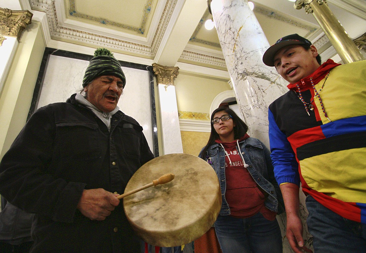 FILE - In this Feb. 18, 2020, file photo, a protester plays a drum and sings while joined by other Native American protesters opposing the Keystone XL Pipeline at the South Dakota Capitol in Pierre. Major construction projects moving forward along the U.S. borders with Canada and Mexico amid the coronavirus pandemic are raising fears workers could spread infections within nearby communities, including several Native American tribes. (AP Photo/Stephen Groves)