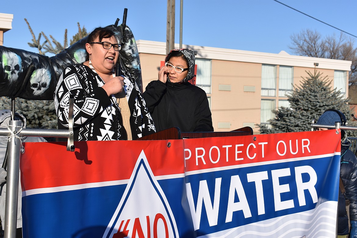 FILE - In this Oct. 29, 2019, file photo, Angeline Cheek, left, a community organizer from the Fort Peck Indian Reservation, speaks about the potential environmental damage from the Keystone XL oil pipeline from Canada during a demonstration in Billings, Mont. Major construction projects moving forward along the U.S. borders with Canada and Mexico amid the coronavirus pandemic are raising fears workers could spread infections within nearby communities, including several Native American tribes. Several of the tribes whose land is skirted by the proposed pipeline route in South Dakota and Montana have enacted stricter measures than the state to protect tribal members from the coronavirus. (AP Photo/Matthew Brown, File)