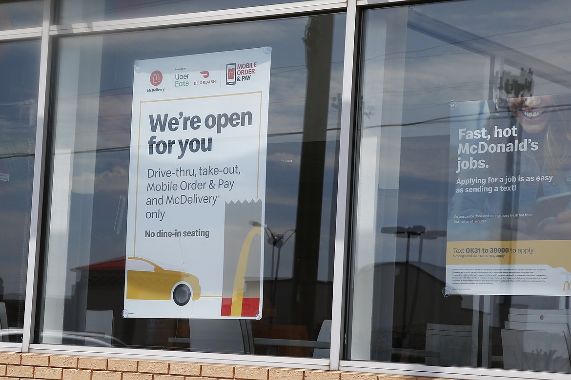 A sign in the window at a McDonald's restaurant states no dine-in seating Thursday, May 7, 2020, in Oklahoma City, where three McDonald's employees suffered gunshot wounds when a customer opened fire because she was angry that the restaurant's dining area was closed because of the coronavirus pandemic, on Wednesday. (AP Photo/Sue Ogrocki)