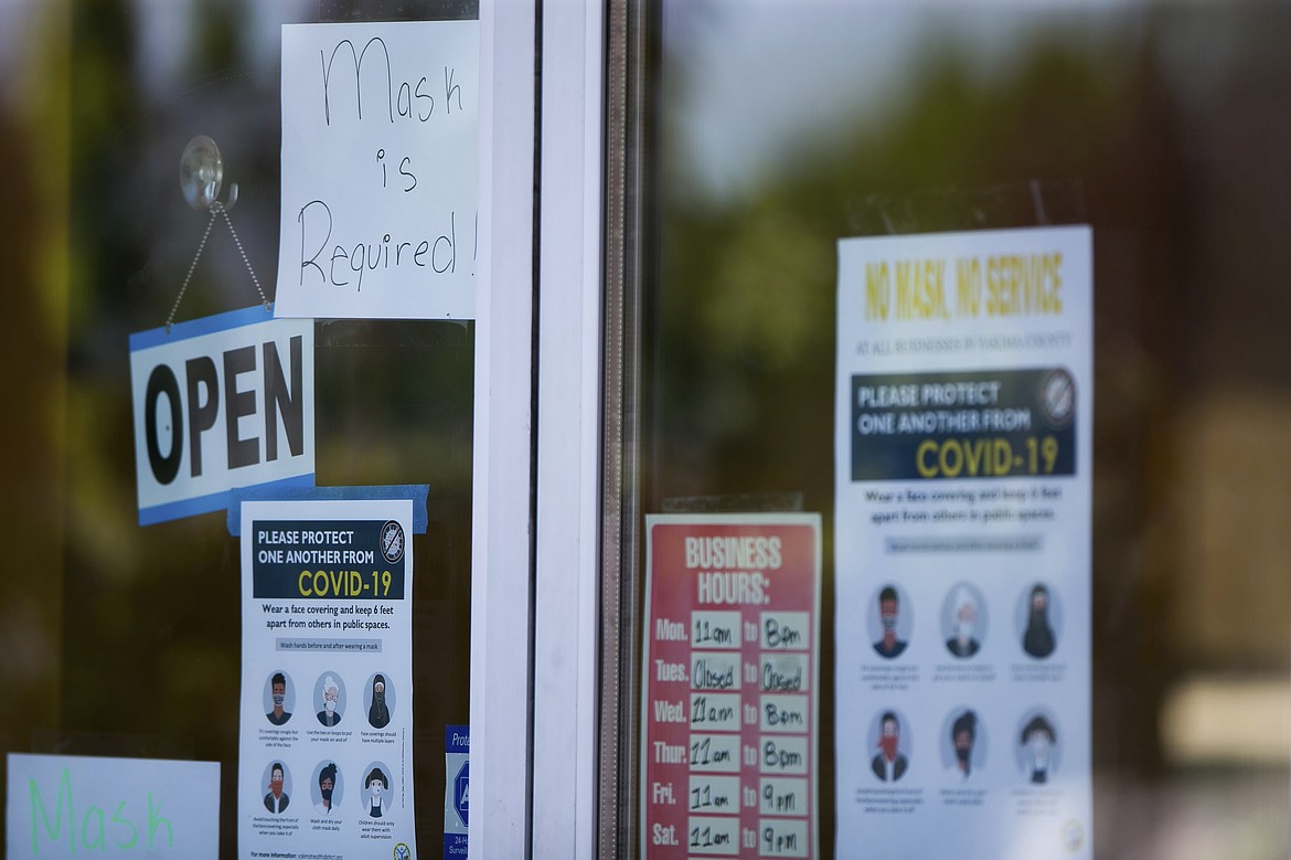 A sign that reads, "Mask is required!" is tapped to the front entrance of Nino's Mexican Grill Monday, June 22, 2020, in Yakima, Wash. Washington state will require people to wear facial coverings in most indoor and outdoor public settings, under a statewide public health order announced Tuesday by Gov. Jay Inslee in response to ongoing COVID-related health concerns. (Amanda Ray / Yakima Herald-Republic via AP)